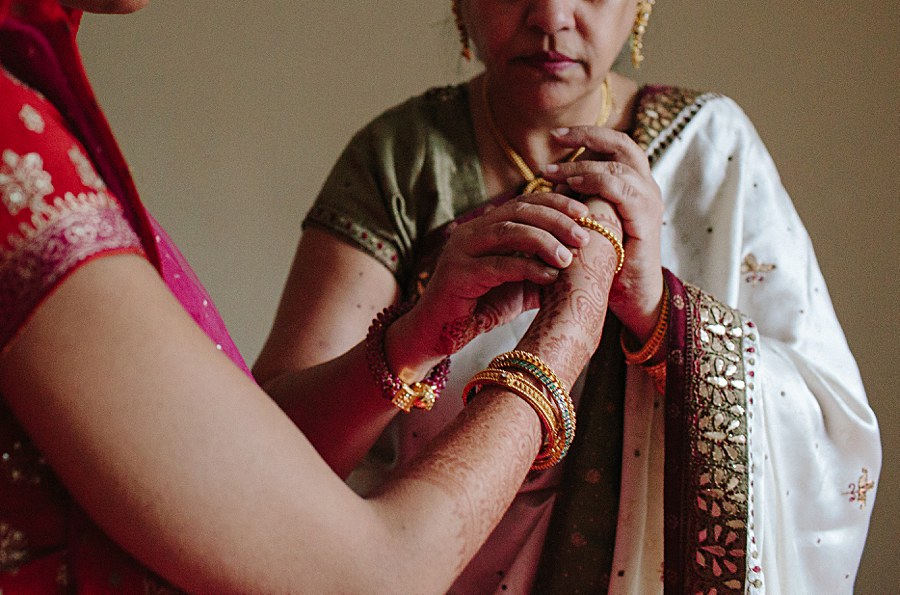 Indian bride putting bracelets on